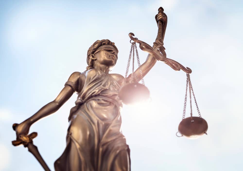 Legal law concept statue of Lady Justice with scales of justice sky background 
