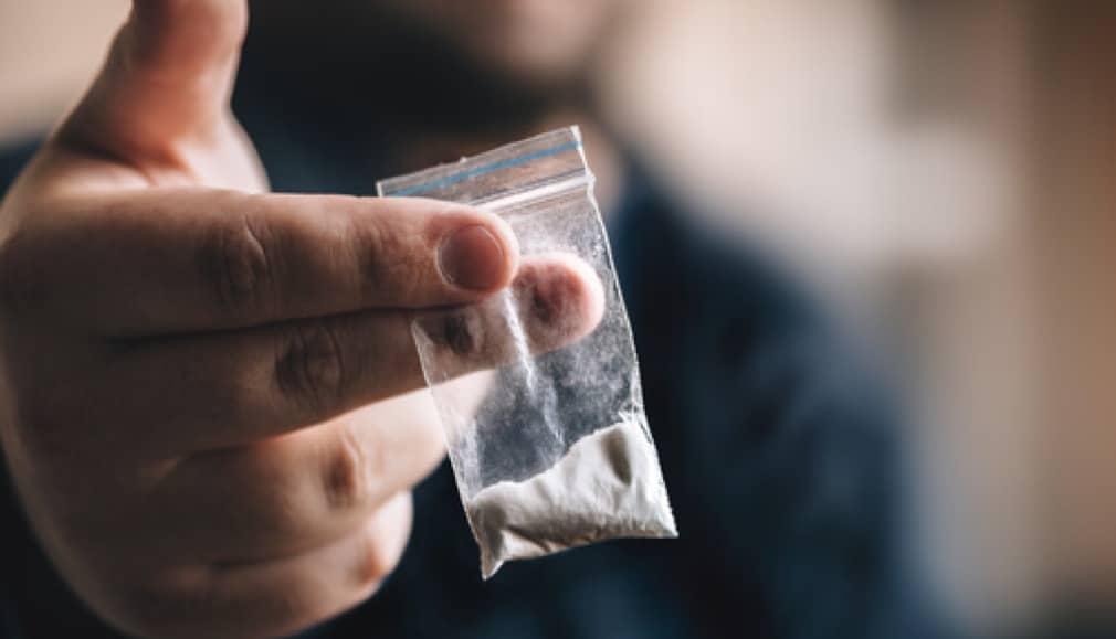 Man holding powder cocaine in bag