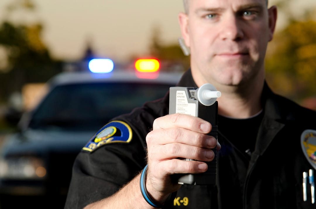 Police officer holding breath alcohol test